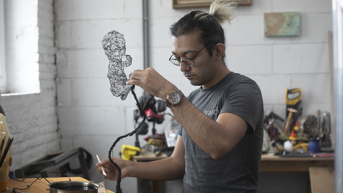 Adding coats of wax to a transparent BT baby sculpture