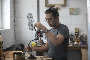Adding coats of wax to a transparent BT baby sculpture